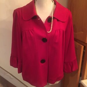 Large red cardigan with black buttons.